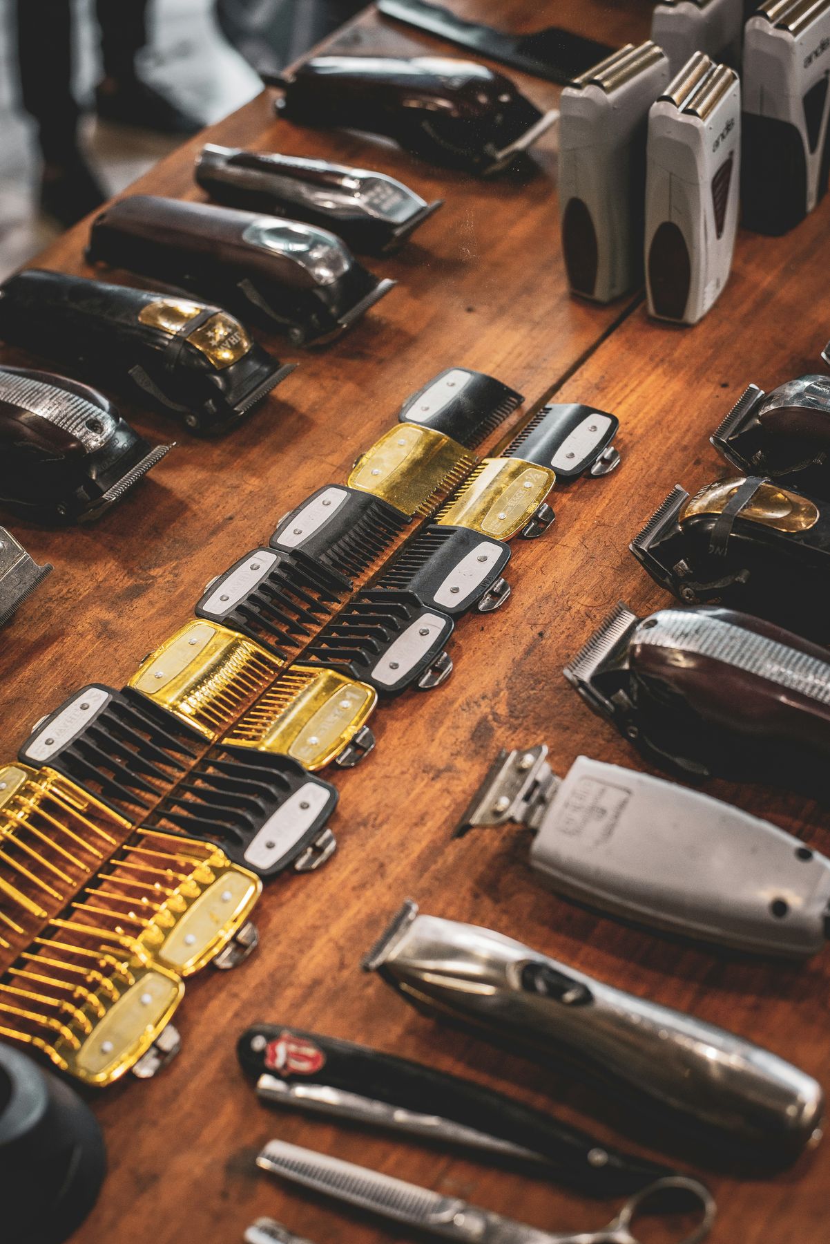 Rows of barber clippers and trimmers on a wooden counter