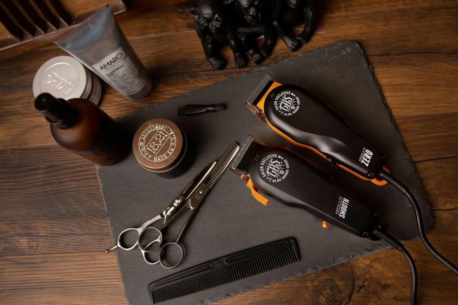 Clippers, scissors, a comb and grooming products on a slate board