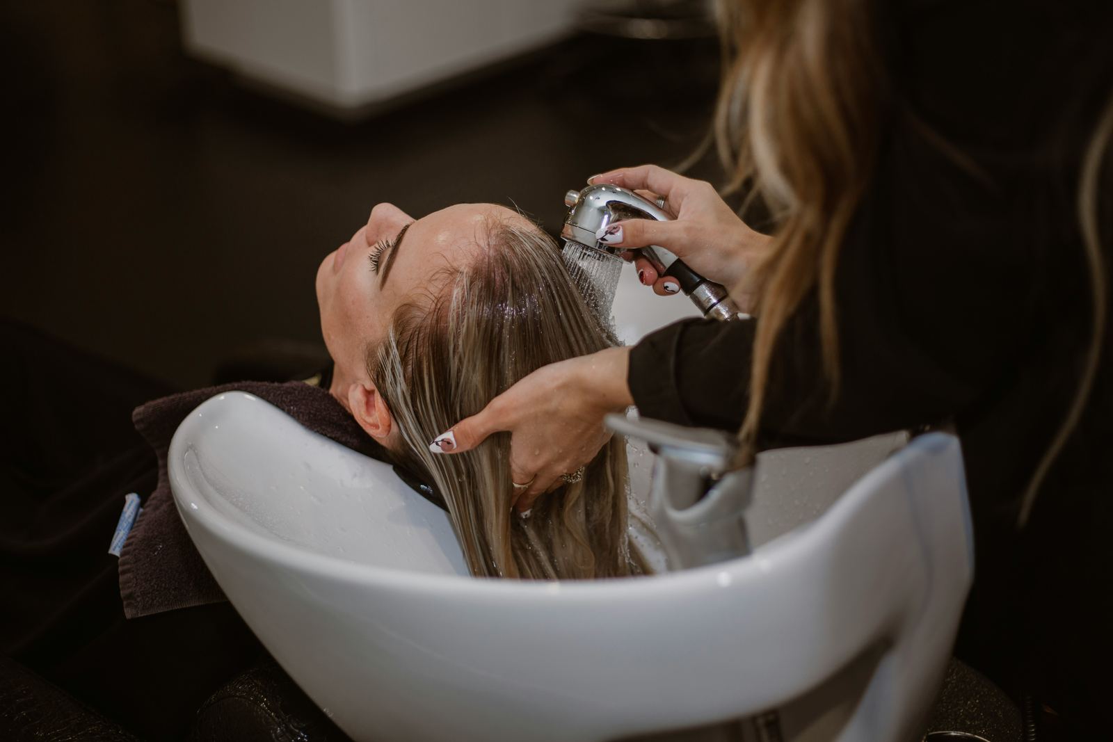 A stylist rinsing a client's hair