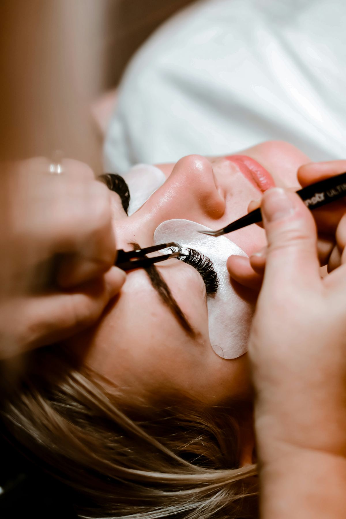 A lash technician applying lash extensions